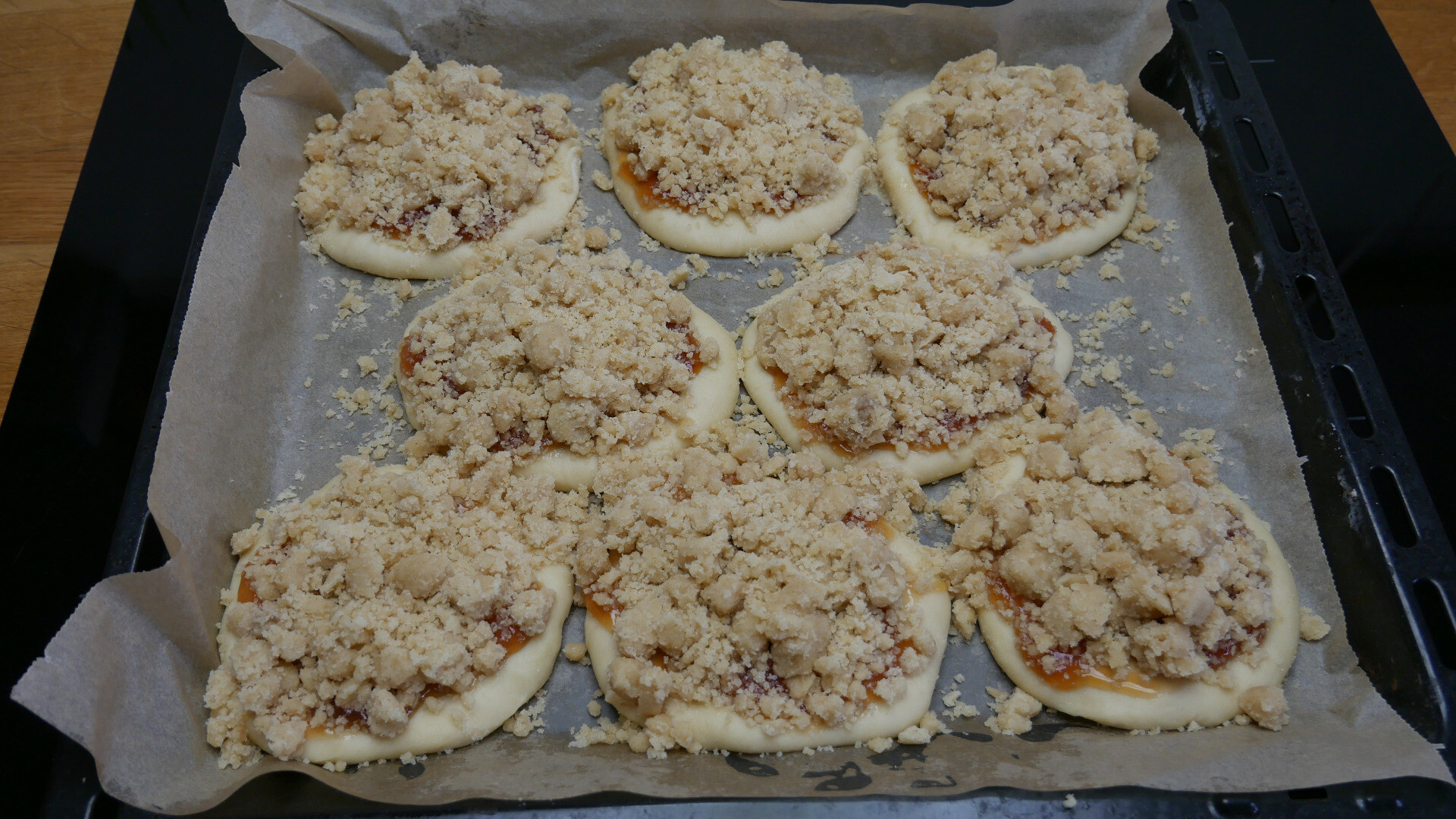 unbaked crumbles on dough with jelly