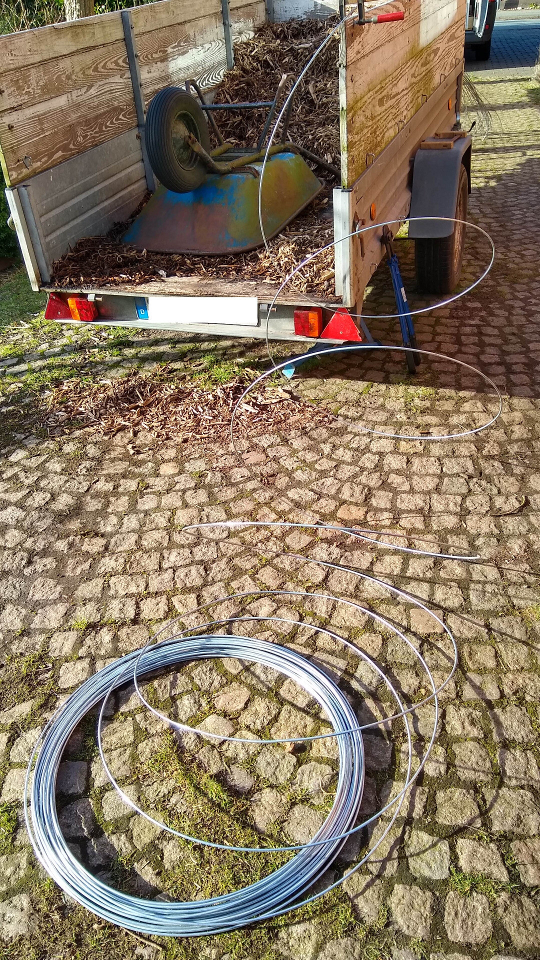 wire coil and a trailer on a driveway