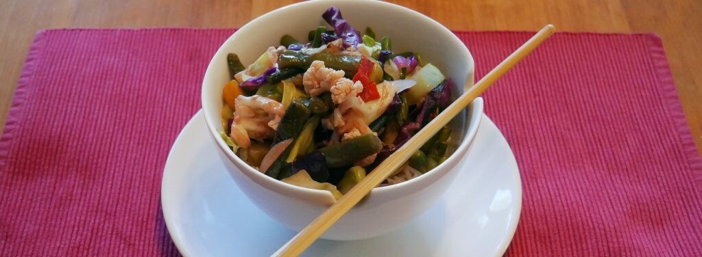 a bowl with chopsticks and veg in sauce