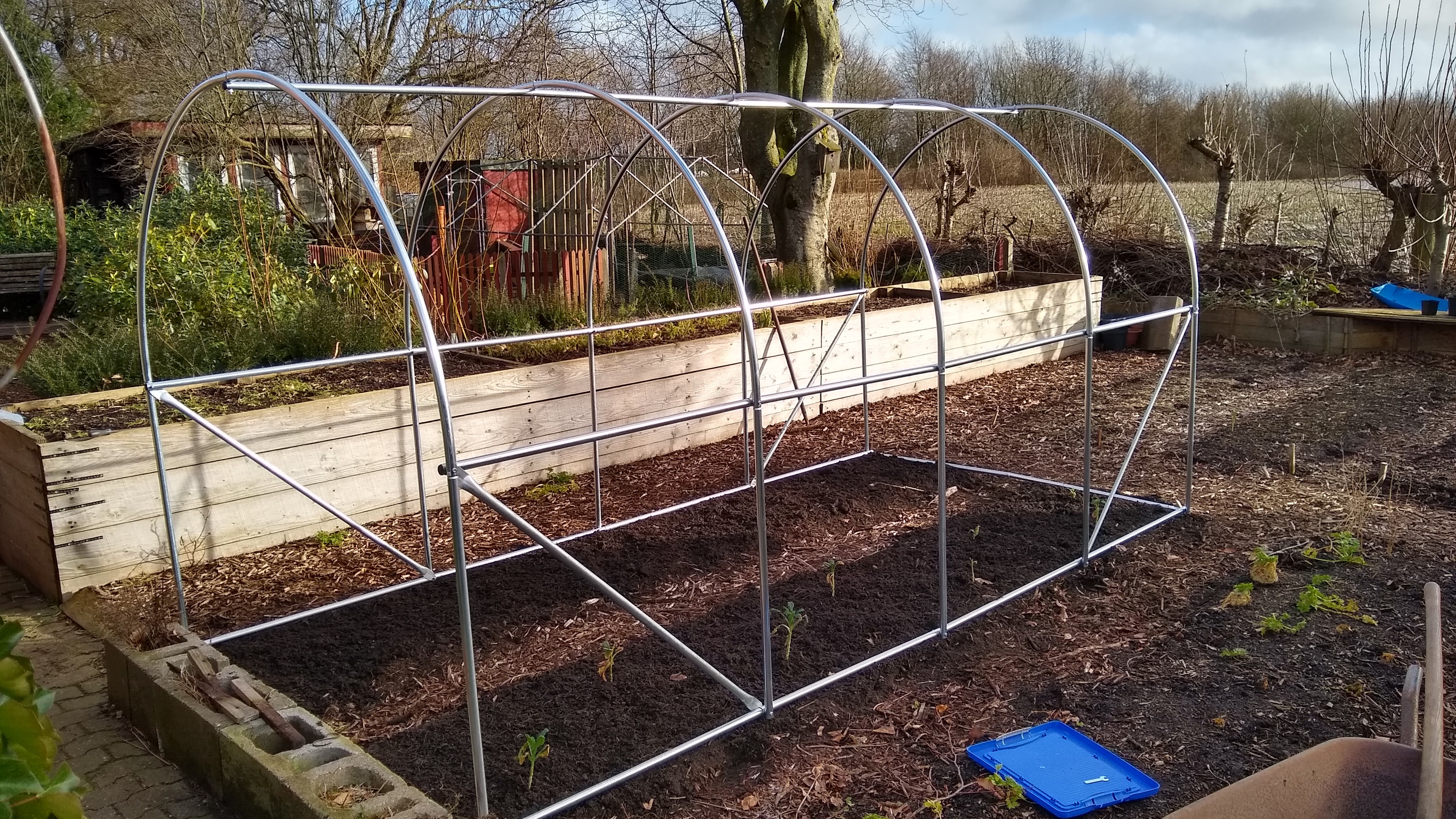 mounted metal parts of a polytunnel in a vegpatch