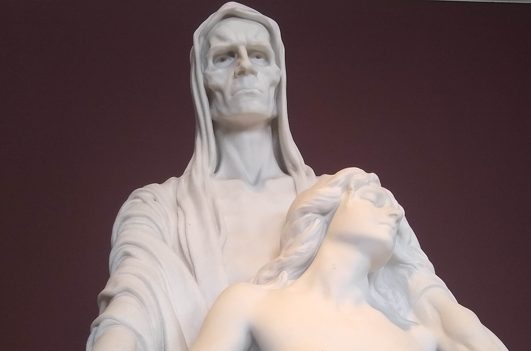 marble sculpture of death holding woman in his arms